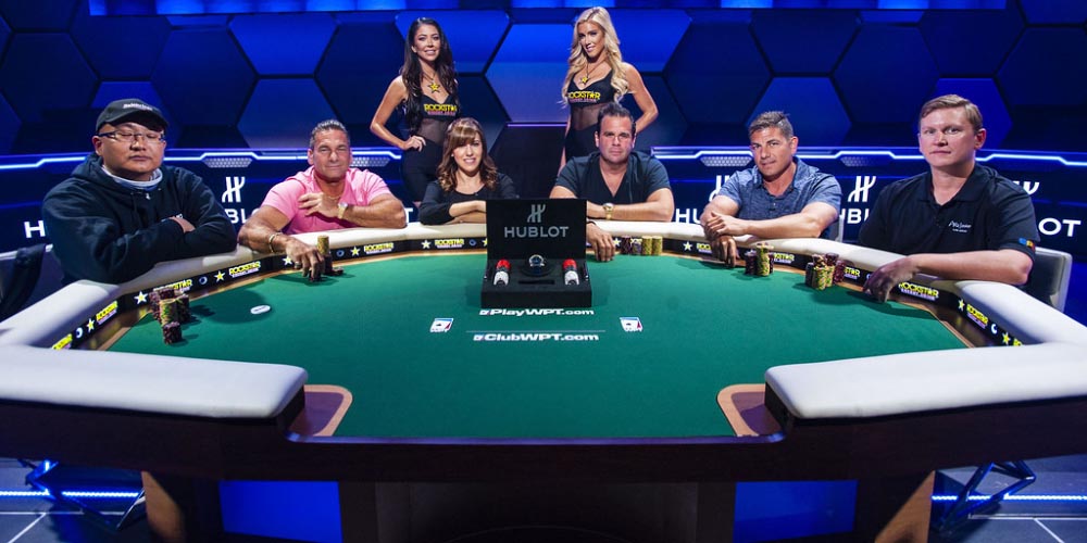 Five professional poker players sitting at the table waiting to play